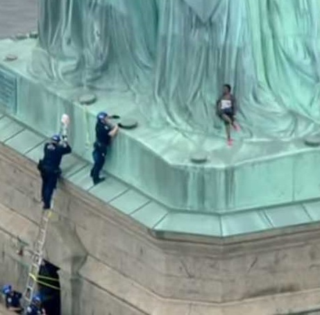 Usa, donna scala la Statua della Libertà contro Trump