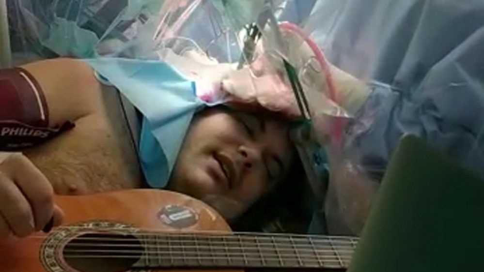 Suona la chitarra mentre viene operato al cervello